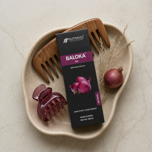 Baloka Onion Hair Oil bottle on a plate with onion and wooden comb